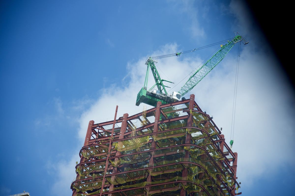 Tower crane on top of a steel-frame building under construction